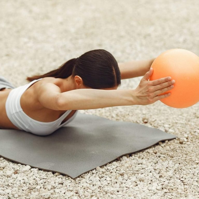 Pretty lady training on a summer beach. Brunette doing yoga. Girl in a sportsuit.
